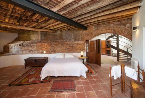 1 dormitorio con cama y pared de ladrillo en Los Pozos de la Nieve, en Constantina