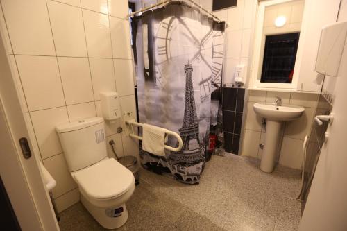 La salle de bains est pourvue d'un rideau de douche et de la tour Eiffel. dans l'établissement Hotel Korzo, à Bitola