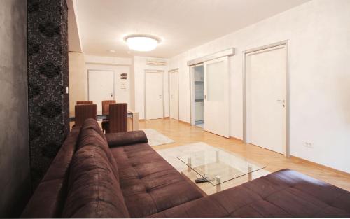 a living room with a brown couch and a glass table at Apartments Belgrade in Belgrade