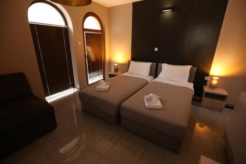 a bedroom with a bed with two shoes on it at Hotel Korzo in Bitola