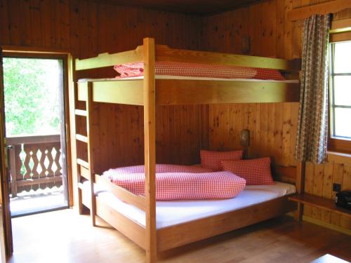 ein Schlafzimmer mit Etagenbetten in einer Holzhütte in der Unterkunft Ferienhaus Wassermühle in Maria Luggau