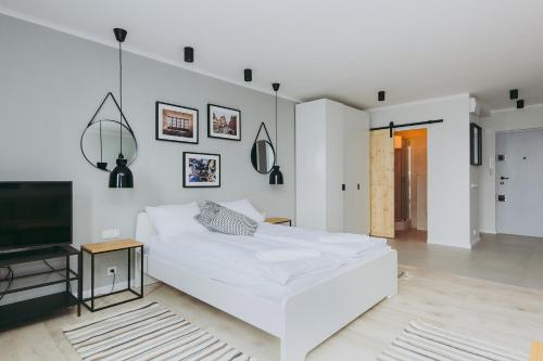 1 dormitorio blanco con 1 cama y TV en ShortStayPoland Pereca (B68), en Varsovia