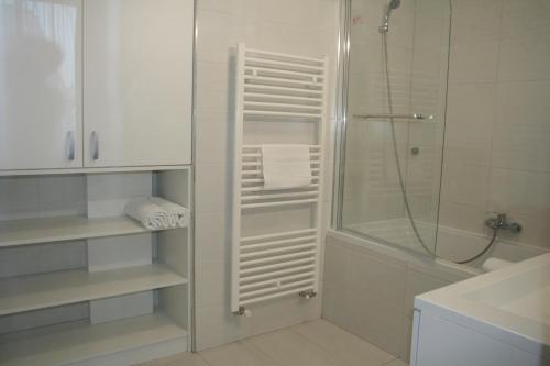Un baño blanco con ducha y lavabo. en Broadway Center Rooftop View Apartment, en Budapest