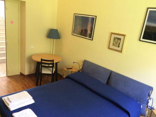 a bedroom with a blue bed and a table at Queen bedroom in Terracina