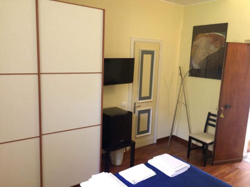 a bedroom with a bed and a chair and a mirror at Queen bedroom in Terracina
