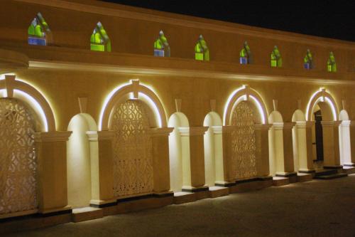 a building lit up at night with green glass bottles at Faletti's Hotel Lahore in Lahore