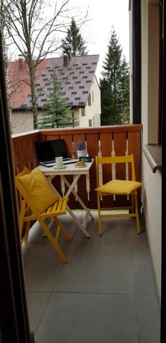 un patio con tavolo e sedie su un balcone di Apartman Goca a Zlatibor