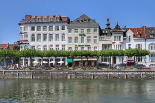 a group of buildings next to a body of water at Fletcher Hotel De Nieuwe Doelen - Middelburg in Middelburg