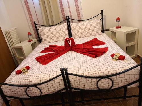 a bed with a red bow on top of it at B&B MANITO in Lavena Ponte Tresa