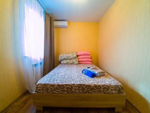 a small bedroom with a bed with colorful pillows at Kvartirkoff na Petra Kalnyshevsky 7, 26 floor in Kyiv