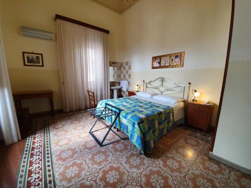 Un dormitorio con una cama y una mesa. en Albergo Cavour en Palermo