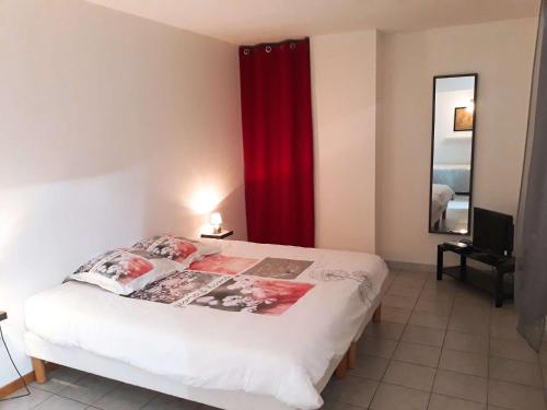 1 dormitorio con 1 cama con cortina roja en Le cabistou, en Devesset