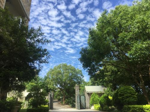 a street with trees and a blue sky with clouds at 响銅鑼民宿 in Tongluo