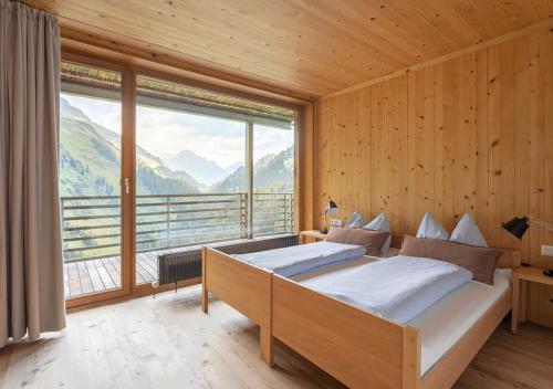a bedroom with a bed and a large window at Lechblick Appartement in Warth am Arlberg