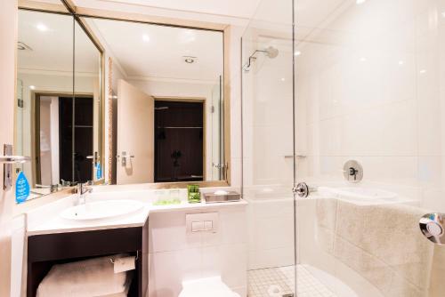 a bathroom with a tub, sink and mirror at ONOMO Hotel Cape Town – Inn On The Square in Cape Town