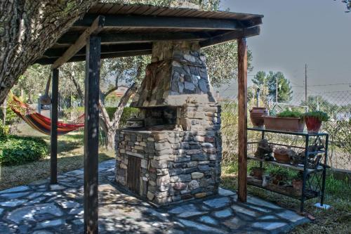 an outdoor brick oven with a wooden roof at Feggaropetra by the Sea(Moonstone) - Trani Ammouda in Ormos Panagias