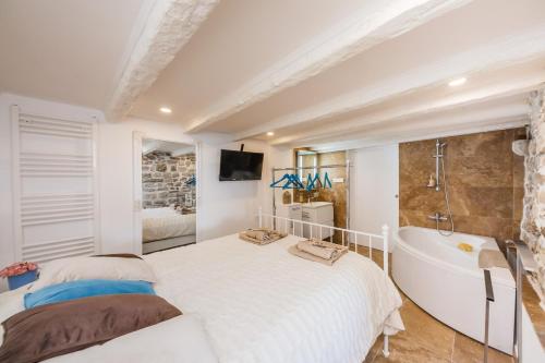 a bedroom with a large bed and a bath tub at Water Castle House in Kaštela