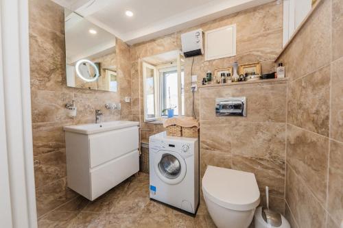 a bathroom with a toilet and a washing machine at Water Castle House in Kaštela