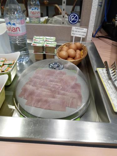 a counter with a plate of meat and eggs at EGG HOTEL - HOTEL LES GENS DE MER Dieppe in Dieppe