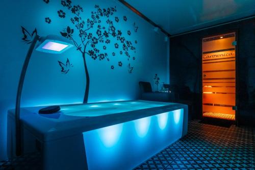 a room with a bed with a tree on the wall at Siedlisko Carownica Family & Wellness in Lechów