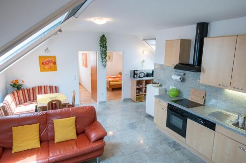a kitchen and living room with a couch and a table at Appartementhaus Freiler in Mörbisch am See