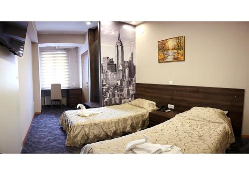 um quarto de hotel com duas camas e uma foto de uma cidade em Hotel Ambasador em Skopje