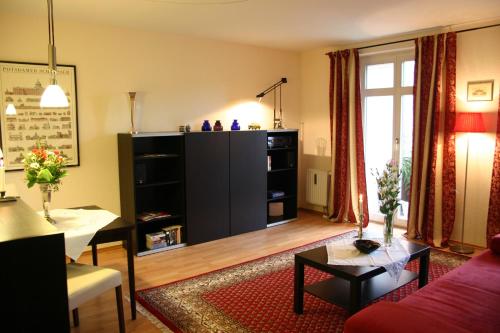 ein Wohnzimmer mit einem Sofa und einem Tisch in der Unterkunft Apartment am Rathaus Potsdam-Babelsberg in Potsdam