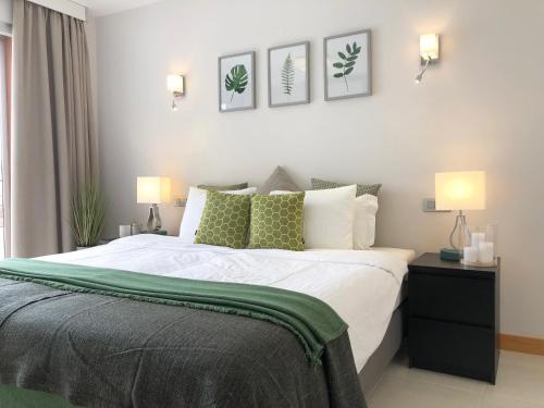 een slaapkamer met een bed met groene en witte kussens bij Vista Golf 15 in La Playa de Arguineguín