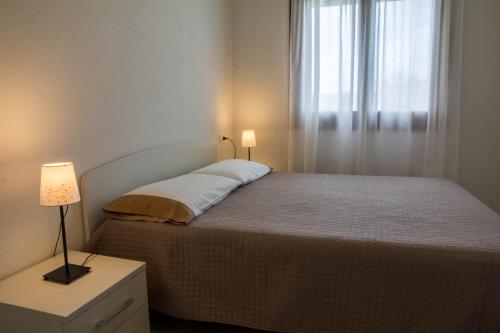 a bedroom with a large bed with a window at GF Apartments La Vigna in Badesi