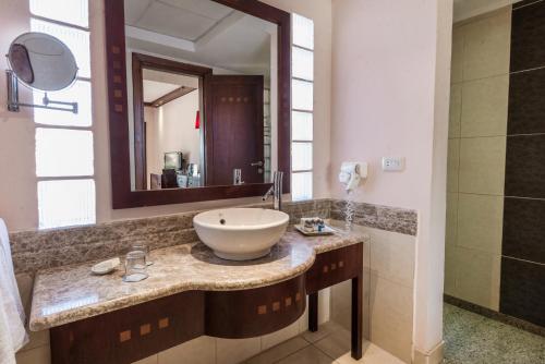 a bathroom with a sink and a mirror at Shams Prestige Abu Soma (Adults Only) in Hurghada