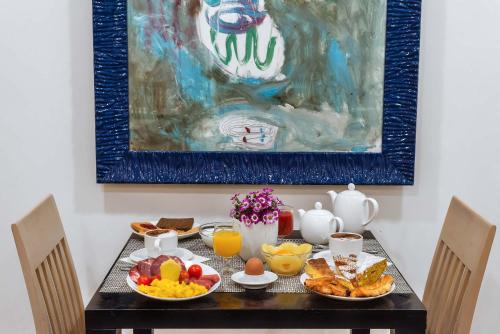 een tafel met ontbijtproducten en een schilderij aan de muur bij Hotel Genova in Rome