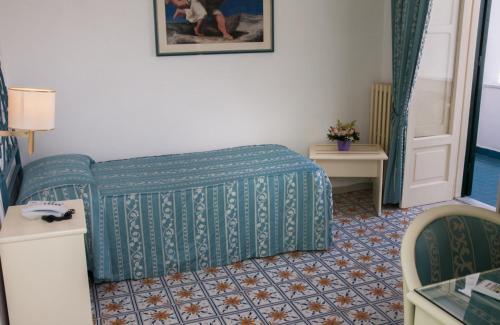 a hotel room with a bed and a table and chairs at Hotel Villa Bianca in Ischia