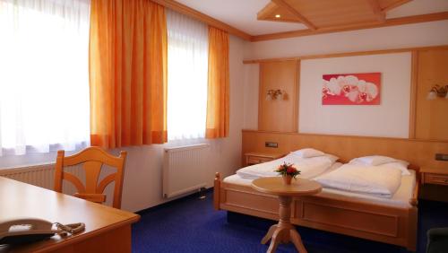 a hotel room with a bed and a table at Hotel zu den Linden in Aschheim