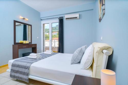 a blue bedroom with a bed and a window at Sunny by the Beach in Chrysi Ammoudia