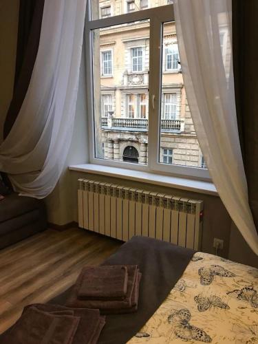 een slaapkamer met een bed en een groot raam bij New Appartment-studio іn the center of Lviv in Lviv