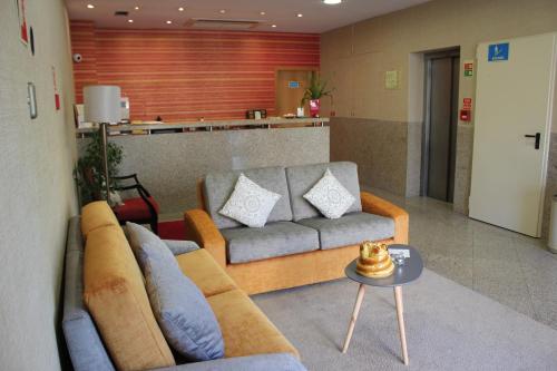 a living room with a couch and a table at Hotel dos Loios in Santa Maria da Feira
