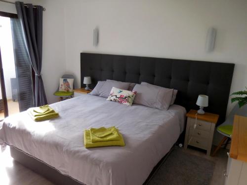 1 dormitorio con 1 cama grande y 2 toallas amarillas. en Apartamento Deluxe Quinta da Bellavista by Umbral, en Albufeira