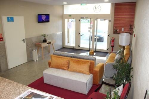 a living room with a couch and a chair at Hotel dos Loios in Santa Maria da Feira