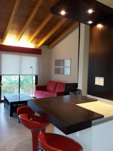 a living room with a table and red chairs at Cabaña en Barrio Privado de Potrerillos in Potrerillos