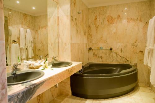 a bathroom with two sinks and a large tub at La Cueva Park in Jerez de la Frontera