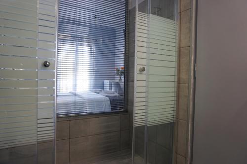 a bathroom with a glass shower with a window at Liprando in Naousa