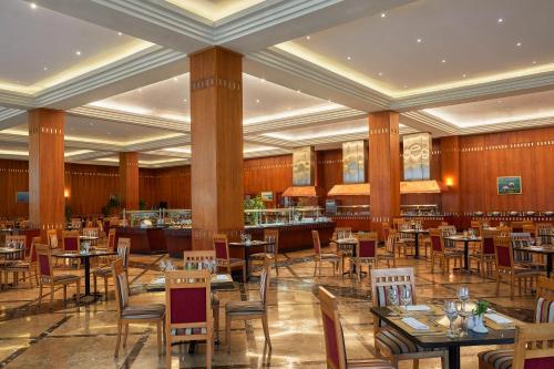 a restaurant with tables and chairs and a bar at JAZ Grand Marsa in Coraya Bay