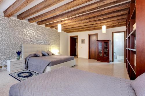 ヴェネツィアにあるCa Serenissimaの木製の天井が特徴の広いベッドルーム1室(ベッド2台付)が備わります。