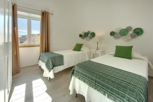 a bedroom with two beds and a window at Apartamentos Tucha in Albufeira