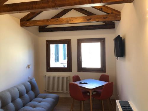 ein Wohnzimmer mit einem Sofa und einem Tisch in der Unterkunft Bianca Cappello House in Venedig