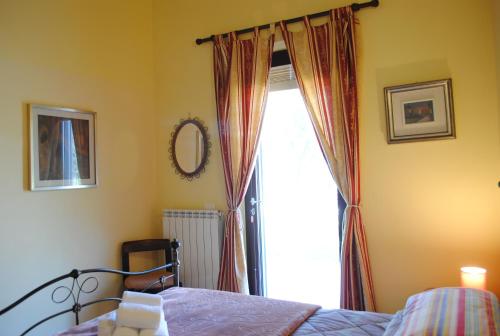a bedroom with a bed and a window at AGRITURISMO MELOGRANO D'ORO in Bardolino