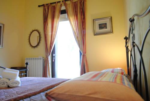 a bedroom with a bed and a large window at AGRITURISMO MELOGRANO D'ORO in Bardolino