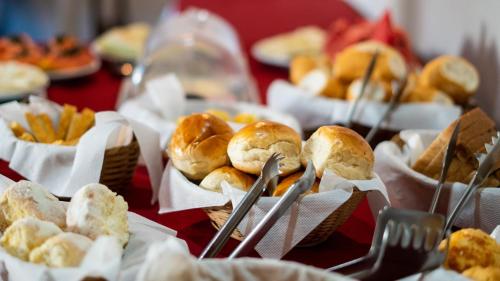 a table topped with baskets of buns and snacks at Pousada Solar da Inconfidência - fácil acesso a Praça Tiradentes in Ouro Preto