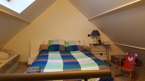 ein Schlafzimmer mit einem Bett im Dachgeschoss in der Unterkunft homedelabaie in Pontorson