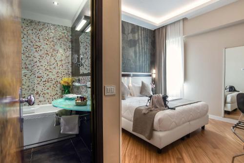- une chambre avec un lit, une baignoire et une table dans l'établissement Hotel Memphis, à Rome